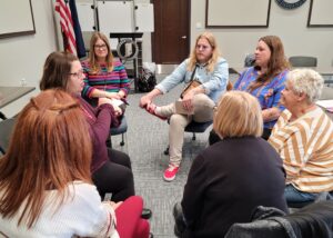 Seven people sitting in a group discussion.
